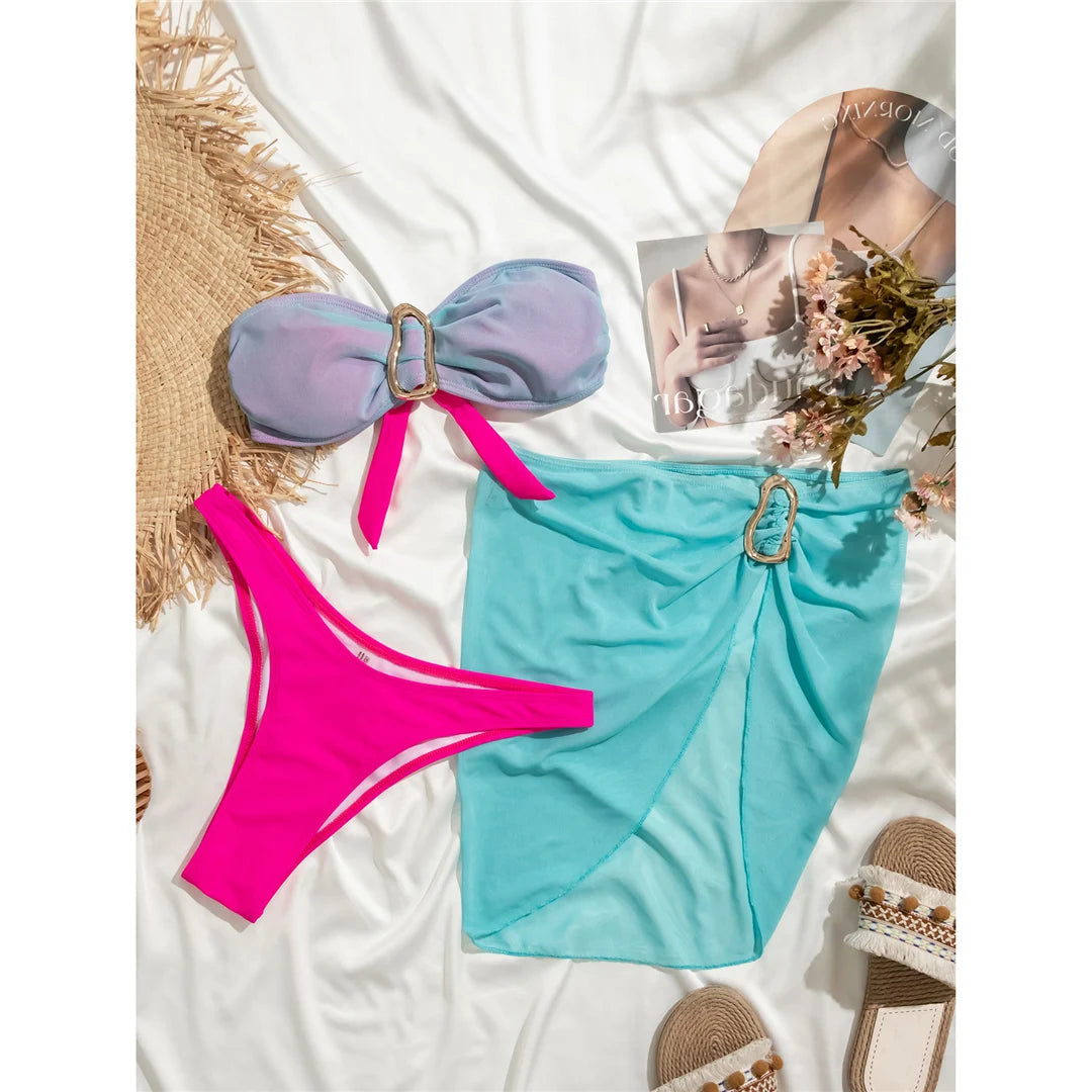 Bandeau with Skirt Splicing Bikini Set, ein dreiteiliges Bademoden-Ensemble, erhältlich in den Größen S bis L. Aus Nylon und Spandex, mit verspieltem Patchwork-Muster. Das Bandeau-Oberteil und der Spleiß-Rock bieten einen frischen und schicken Look für jede Wasserumgebung. Kabelloses Design und niedrige Taille für Komfort und Leichtigkeit. Erhältlich in Lake Blue Pink, Lake Blue, Pink, und Multicolor. Perfekt für alle, die sowohl Stil als auch Abwechslung in ihrer Badekleidung zu schätzen wissen.