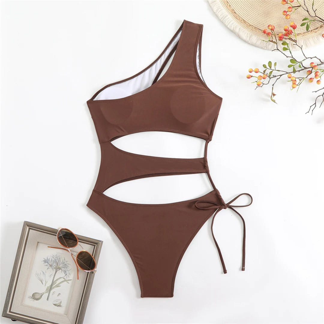 Cut out asymmetric one shoulder one piece swimsuit in red, black, and coffee with high leg design.