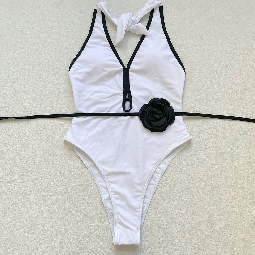 Embrace elegance with an exquisite splicing halter one piece swimsuit featuring backless design and 3D flower belt detailing. Perfect for those who value style and comfort, this monochrome patchwork monokini is made from polyester, spandex, and polyamide, with adjustable shoulder straps and supportive pads. Ideal for women's beachwear collection, available in classic black and white colors.