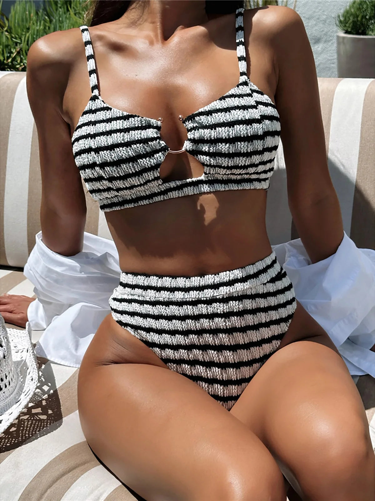 Black and white striped cut-out bikini set, high-waist design, polyester spandex blend, wire-free support, women's two-piece swimwear, chic and flattering silhouette.