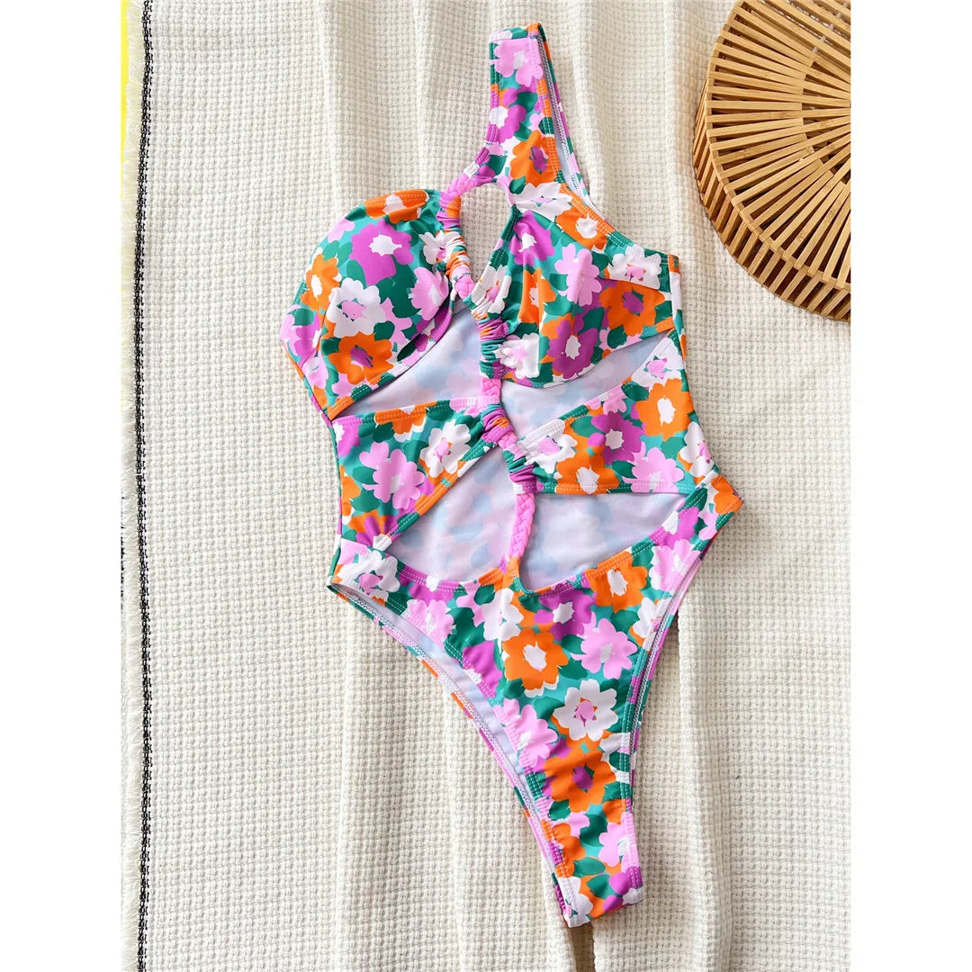 Flowers printed asymmetric cut-out one-piece swimsuit, one-shoulder high-cut design, adjustable triangle top, polyester spandex blend, women's swimwear with vibrant floral prints.